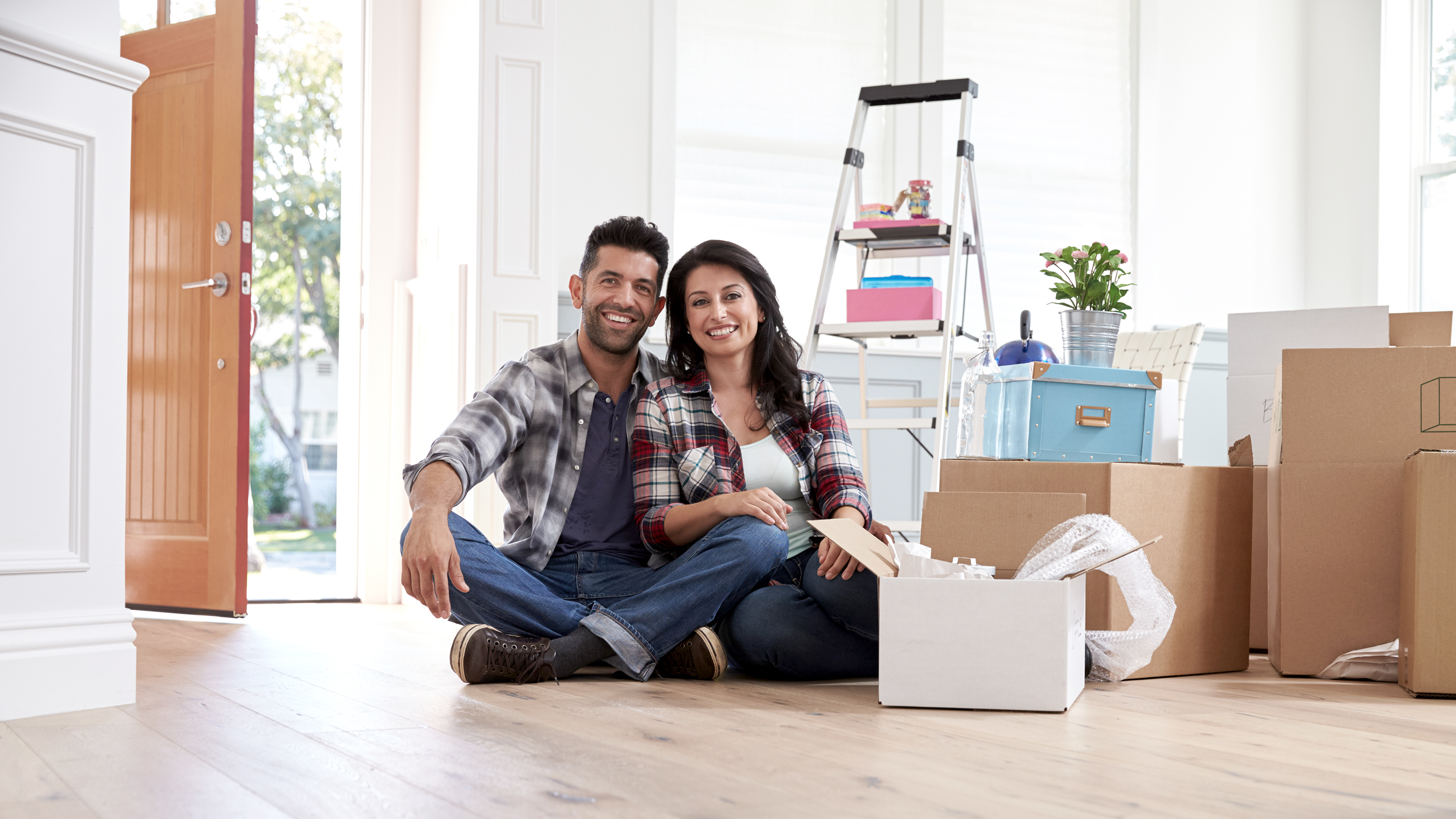 Portrait Of Hispanic Couple Moving Into New Home